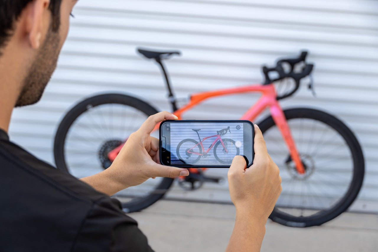 bike seller using their phone to take a photo of a bicycle being listed for sale