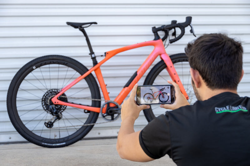 person using their phone to photograph a bike they're going to list for sale