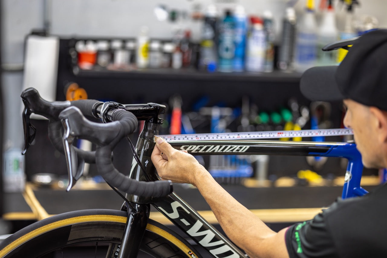 cycle limited employee measuring the size of a bike frame