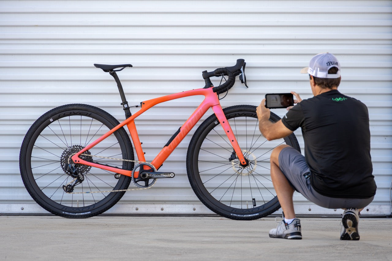 cyclist taking a photograph with their phone of a bike they're listing for sale
