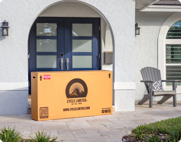 packaged box with cycle limited branding containing a bike sitting on a doorstep